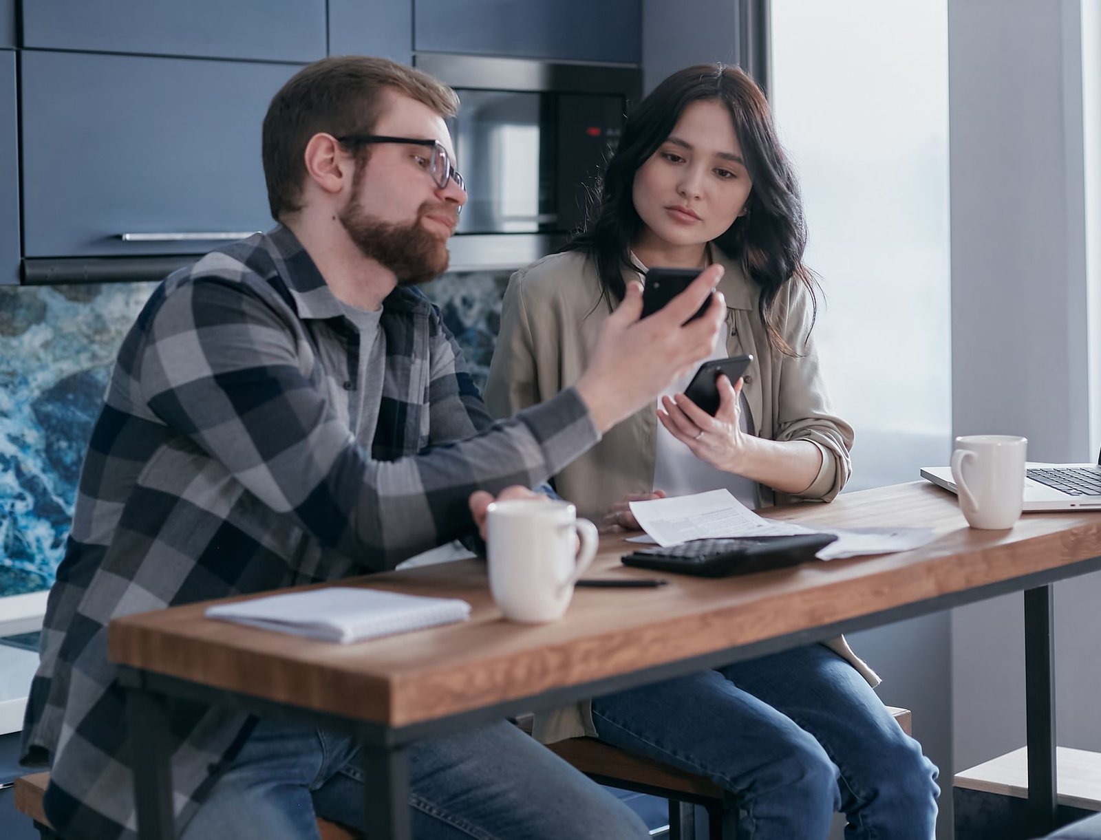 A couple reviewing an AI app subscription and billing at a kitchen table