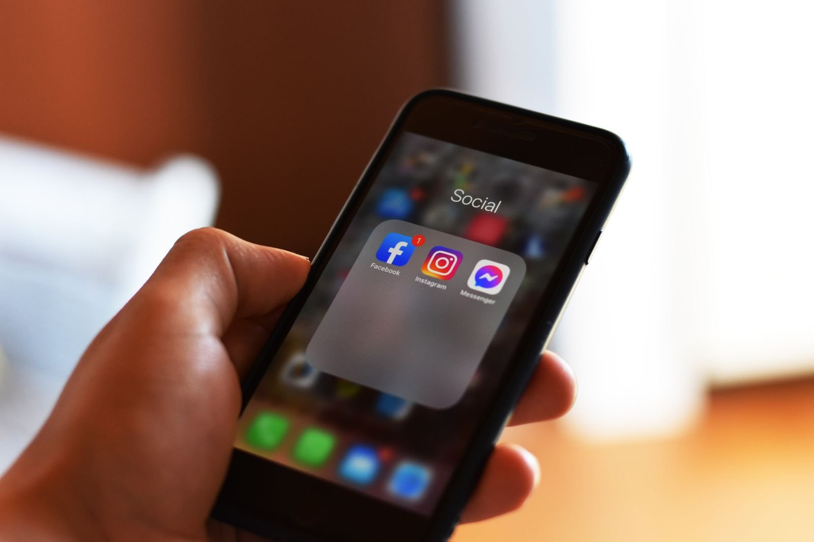 Smartphone in hand showing app subscriptions and monthly charges to review.