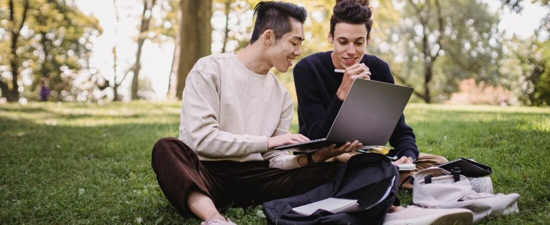 Students using a laptop on a sunny campus, illustrating the best back to school laptop deals 2026