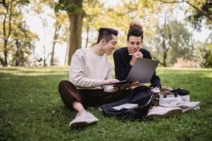 Students using a laptop on a sunny campus, illustrating the best back to school laptop deals 2026