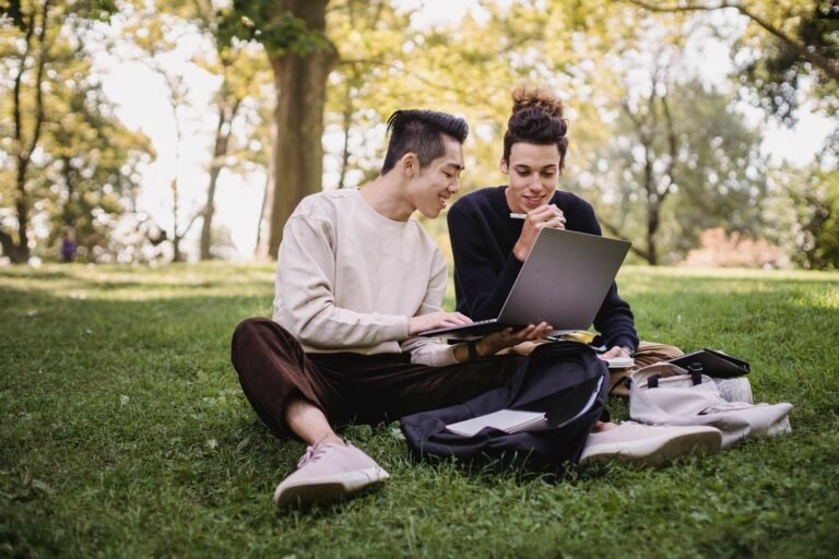 Students using a laptop on a sunny campus, illustrating the best back to school laptop deals 2026