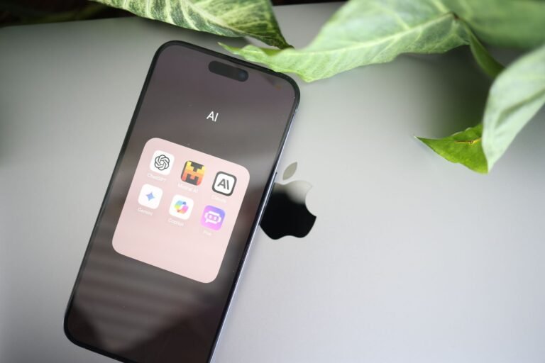 A phone showing a folder of AI apps used to compare and pick the best AI subscription 2026
