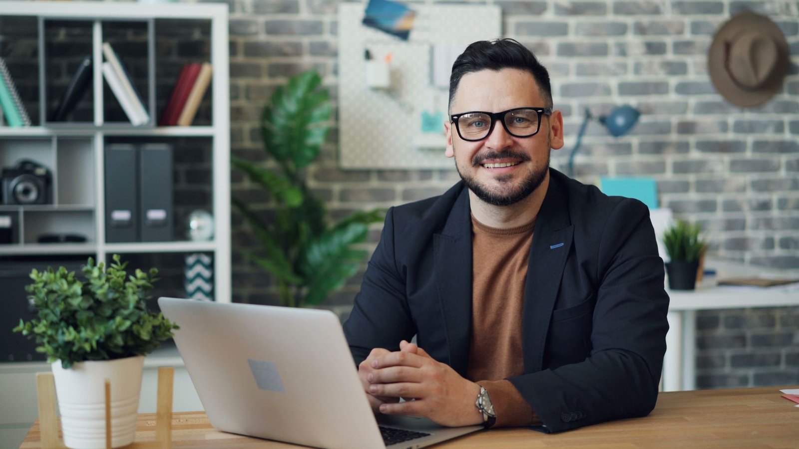 A man in glasses at a laptop, the desk setup the best AR glasses 2026 aim to replace with a virtual screen