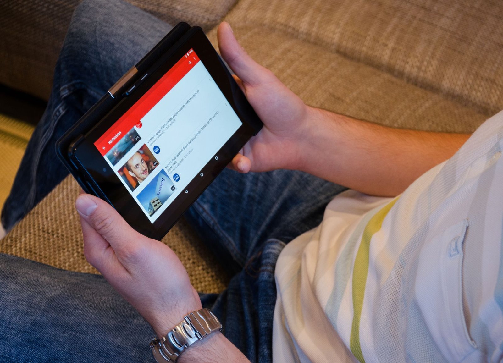 Person using a budget tablet on a couch for streaming and browsing