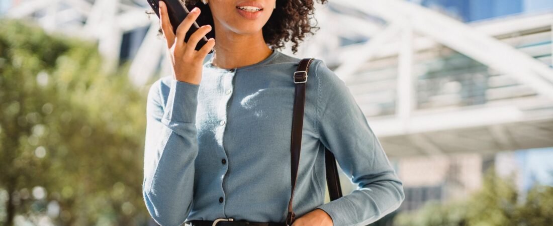 Woman using ChatGPT GPT-Live voice on her smartphone outdoors