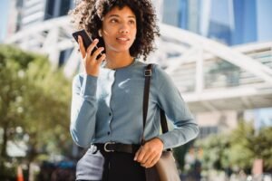 Woman using ChatGPT GPT-Live voice on her smartphone outdoors