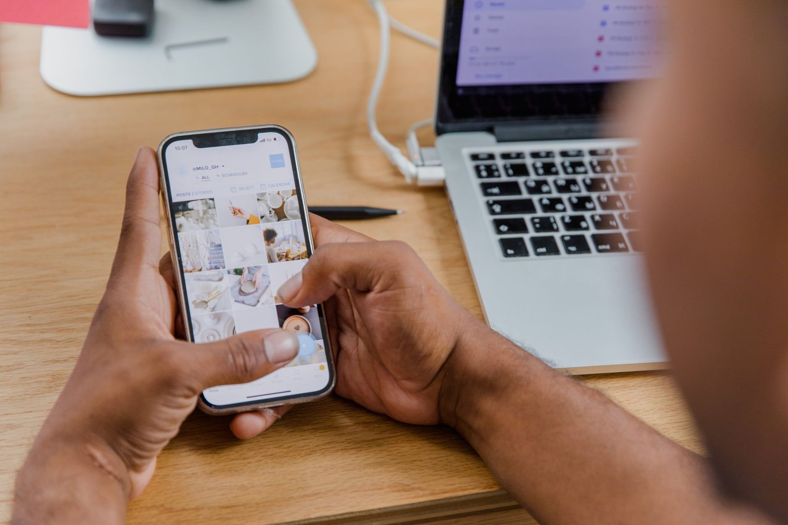 Creator reviewing instagram trial reels results on a phone next to a laptop