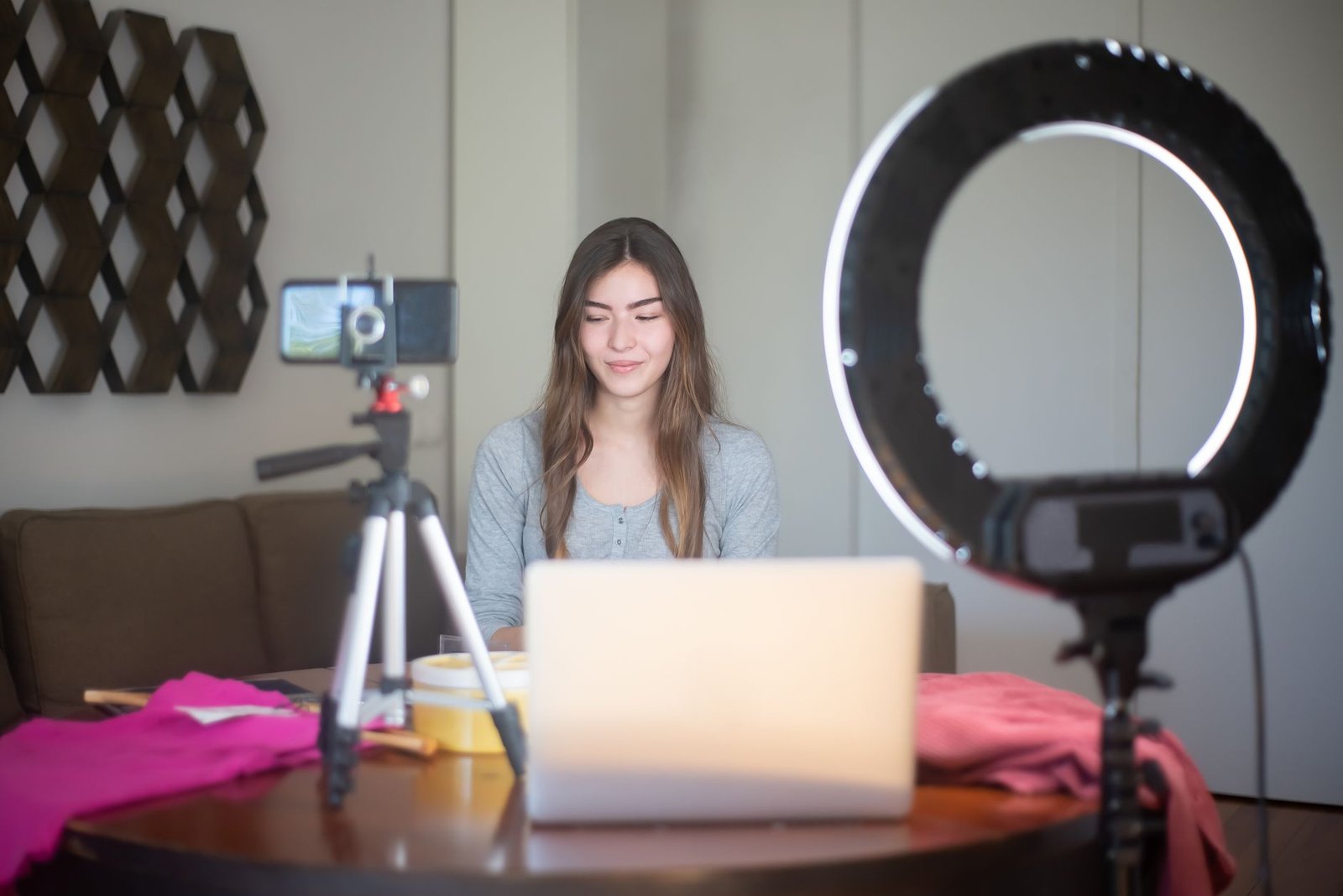 Content creator filming a vertical video with a smartphone on a tripod and ring light