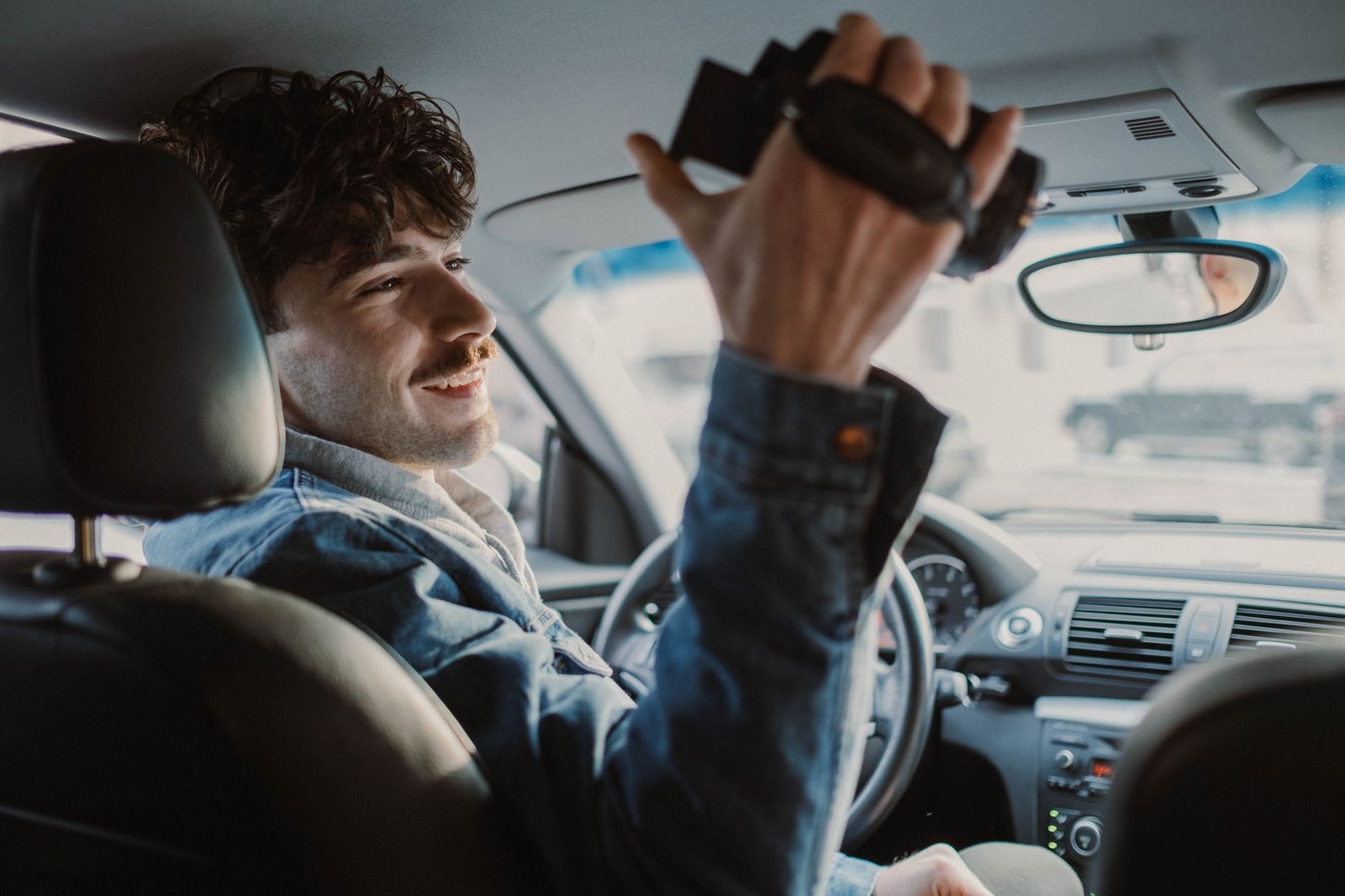 Adjusting a dash cam mounted on the windshield near the rearview mirror