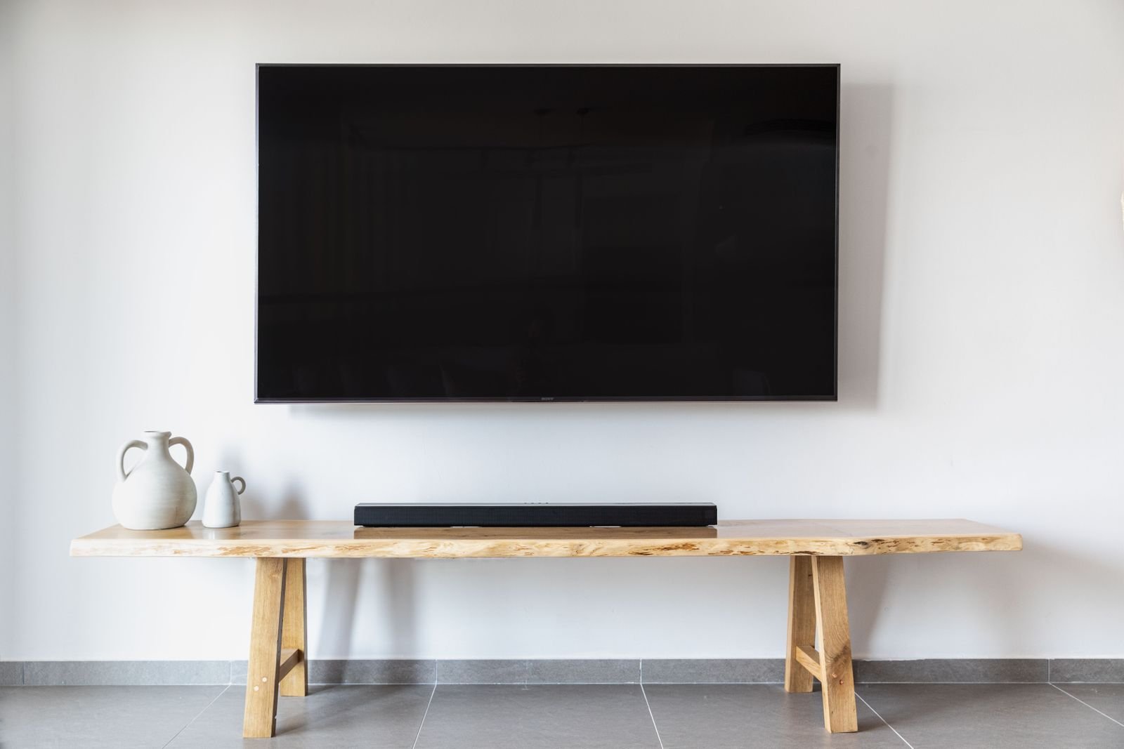 Smart plugs save electricity by scheduling an entertainment center like this TV and soundbar off when nobody is using it.
