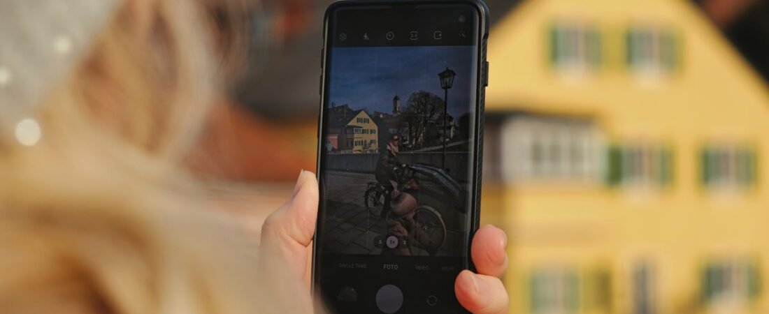 Holding up a phone outdoors to edit and share a bright photo