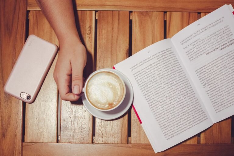 A phone set aside next to coffee and a book, the calm the best screen time app 2026 helps you reclaim