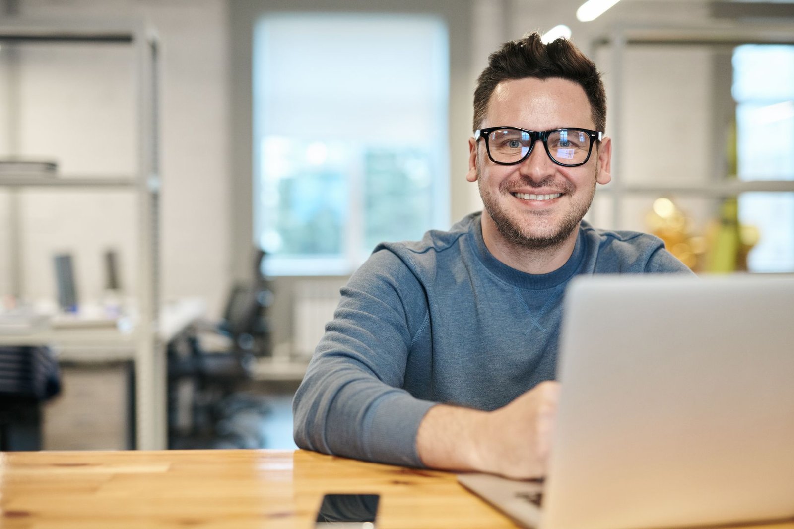 Person smiling while working through lists on a laptop