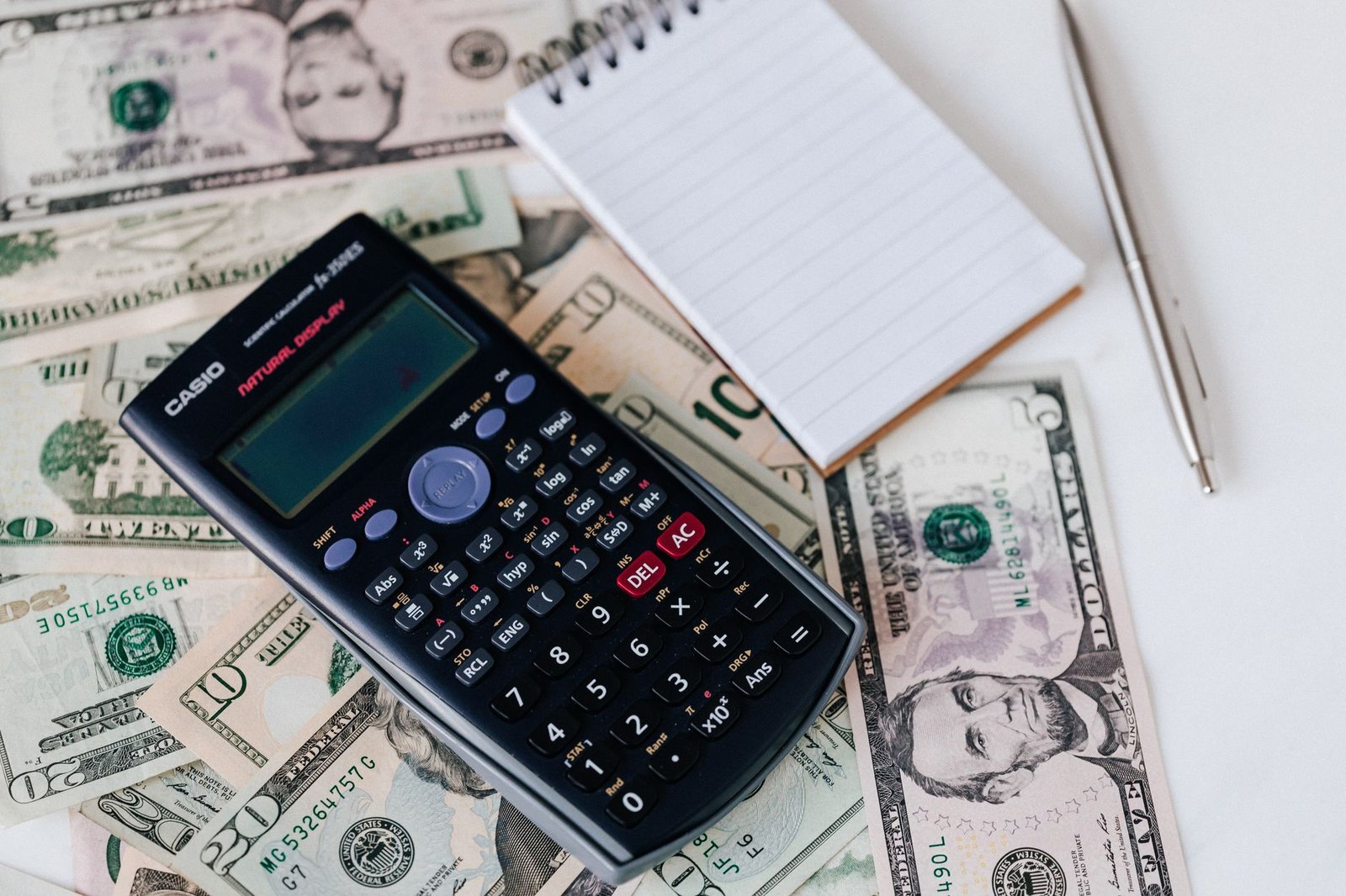 Gamer budgeting for an $80 game purchase, cash and calculator on a desk