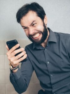 How to stop spam texts: person frustrated by a flood of spam messages on his phone