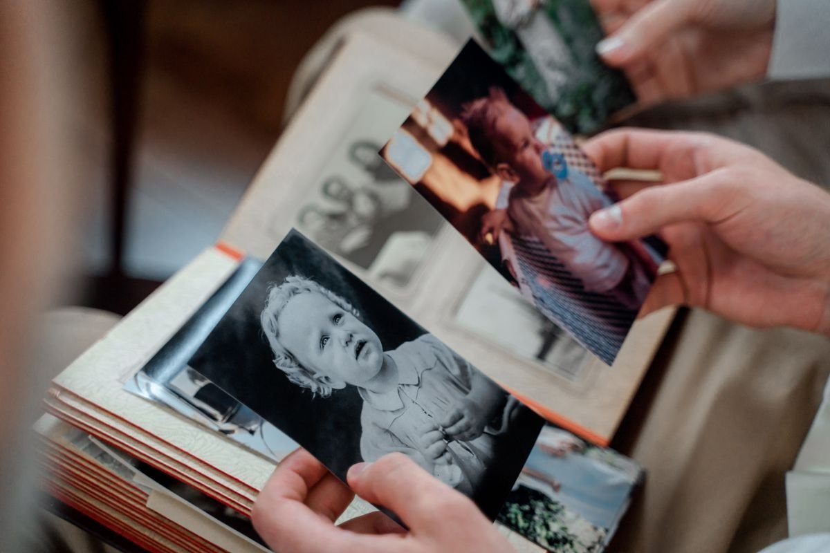 Sorting old faded family photographs to restore with an AI photo restoration app