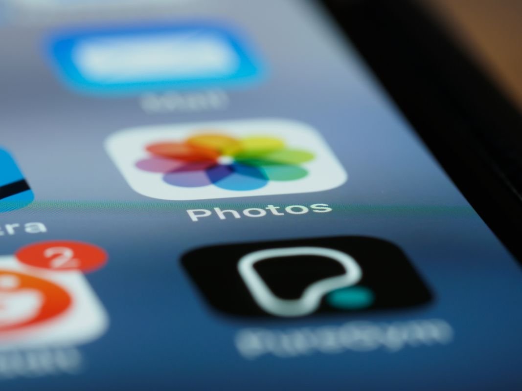 The Photos app icon on an iPhone home screen, a free built-in photo editor