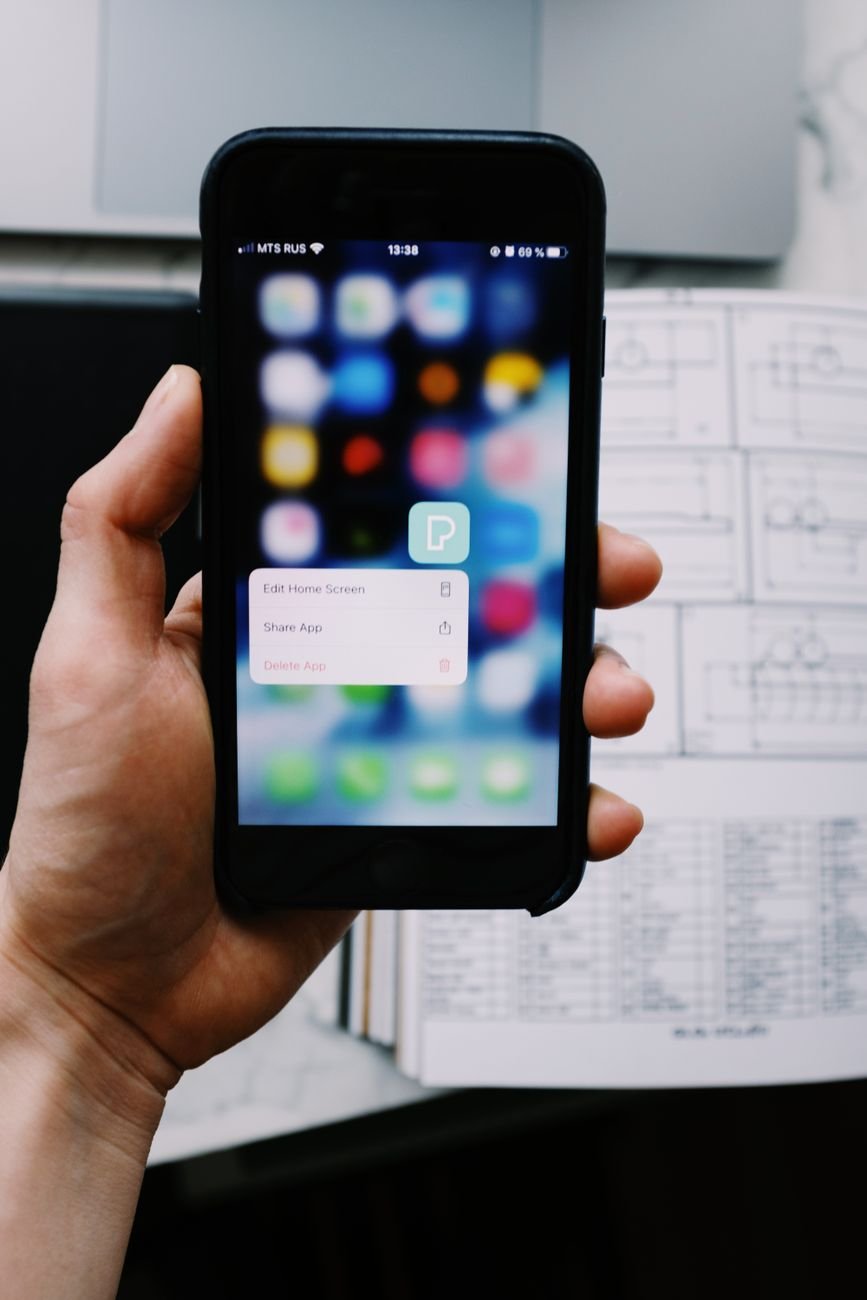 Hand holding an iPhone while adjusting message filtering settings
