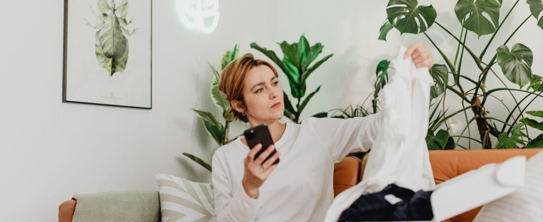 Shopper using a phone to spot fake Amazon reviews on a product listing.
