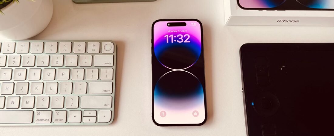 A smartphone set up on a tidy desk beside a keyboard, ready to run automations