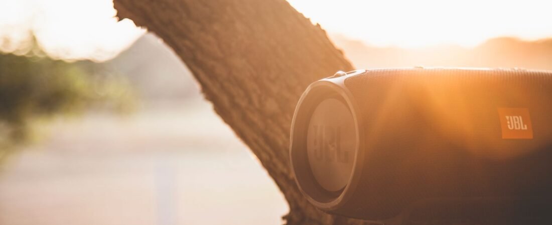 The best portable bluetooth speaker glowing in warm golden sunlight on a summer evening.