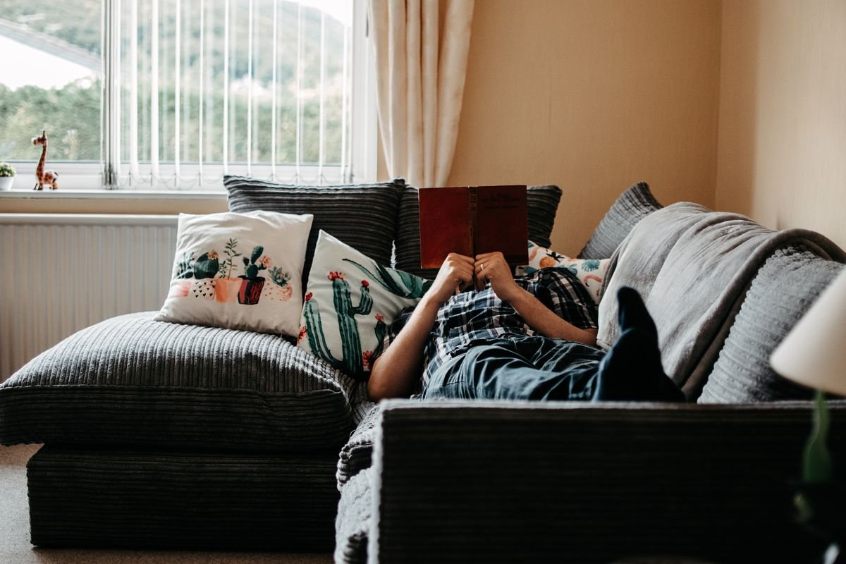 A person relaxing with a book after cutting down phone time