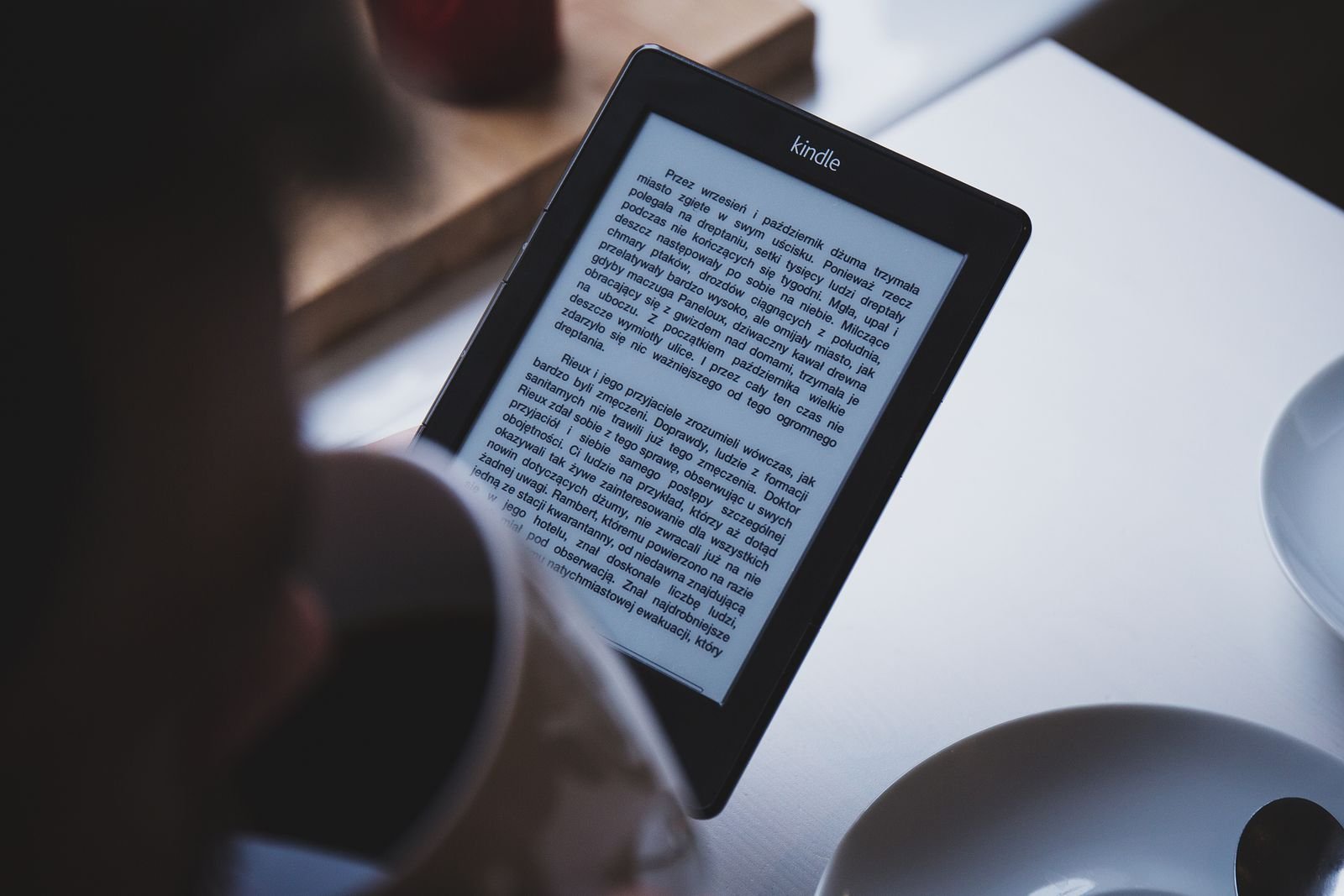 Reading a Kindle e-reader with a morning coffee