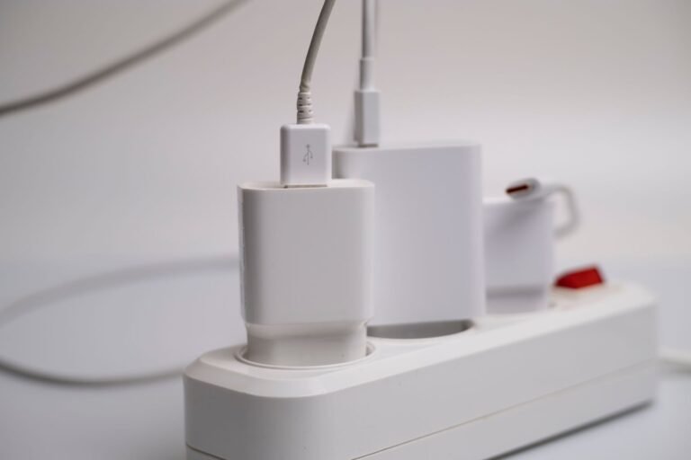 White power strip with chargers plugged in, the standby devices a smart plug can switch off to cut vampire power.
