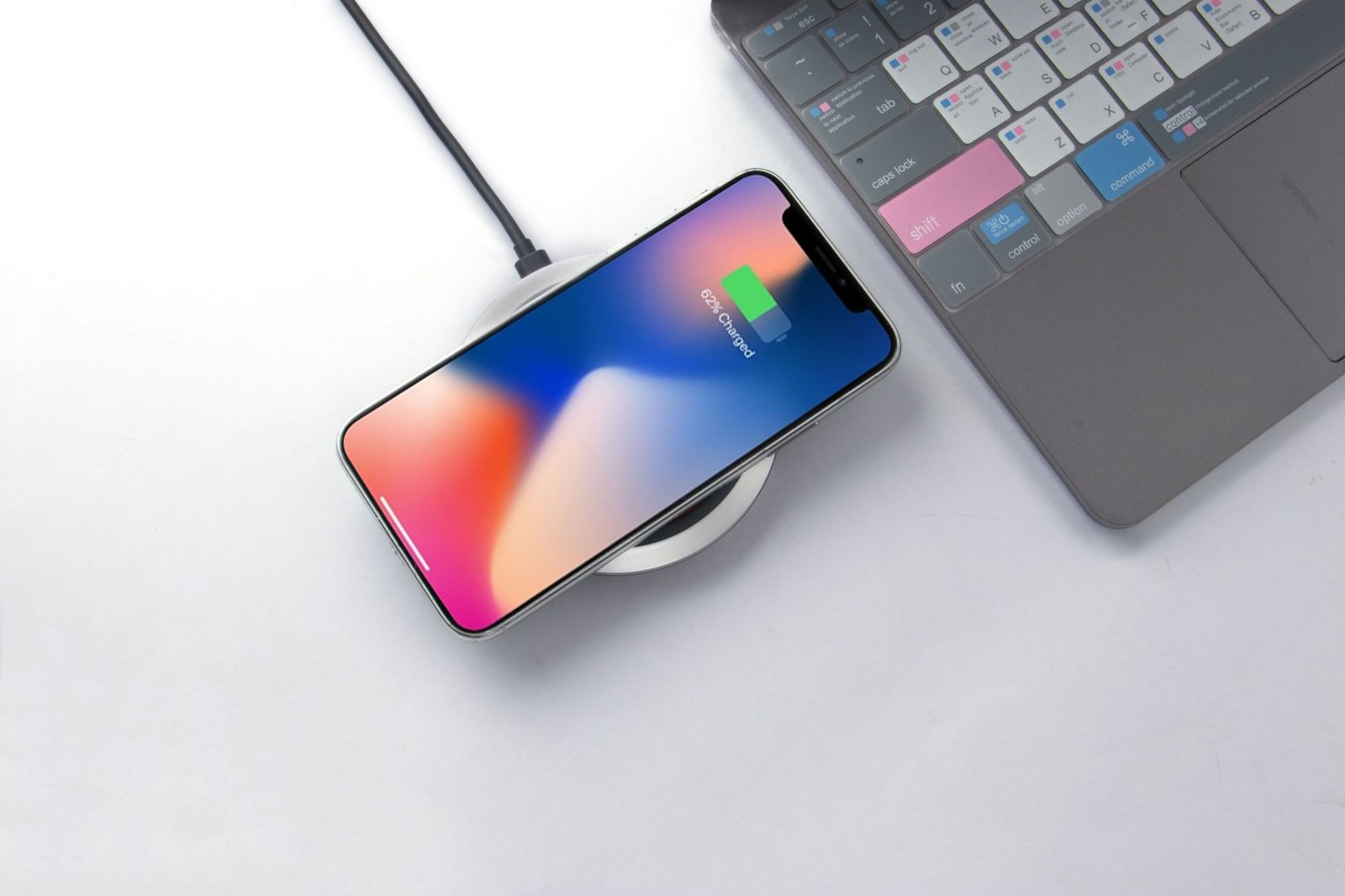 Smartphone charging wirelessly on a desk pad