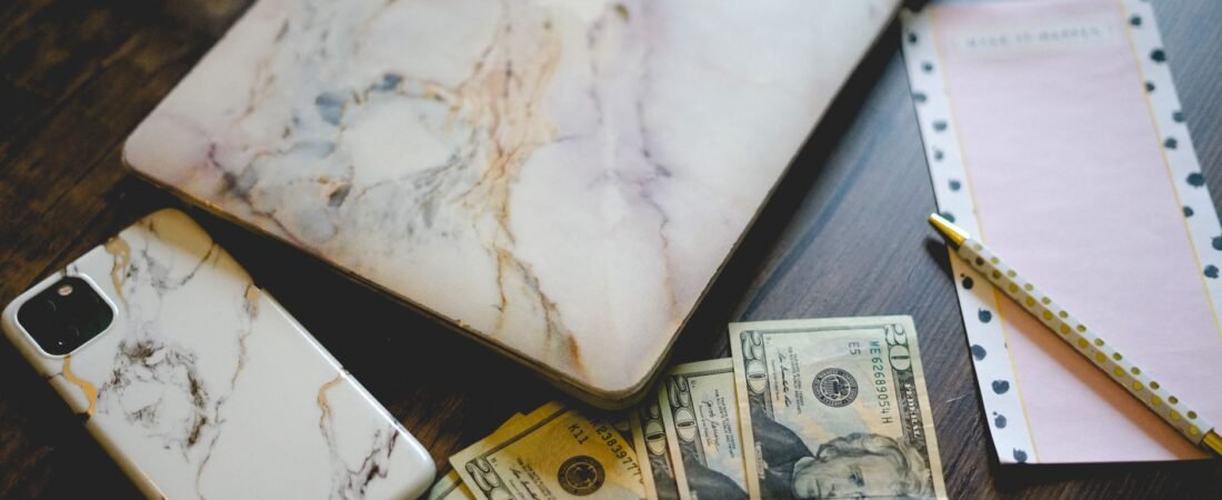 Cheap cell phone plans 2026: a smartphone next to saved cash on a desk.
