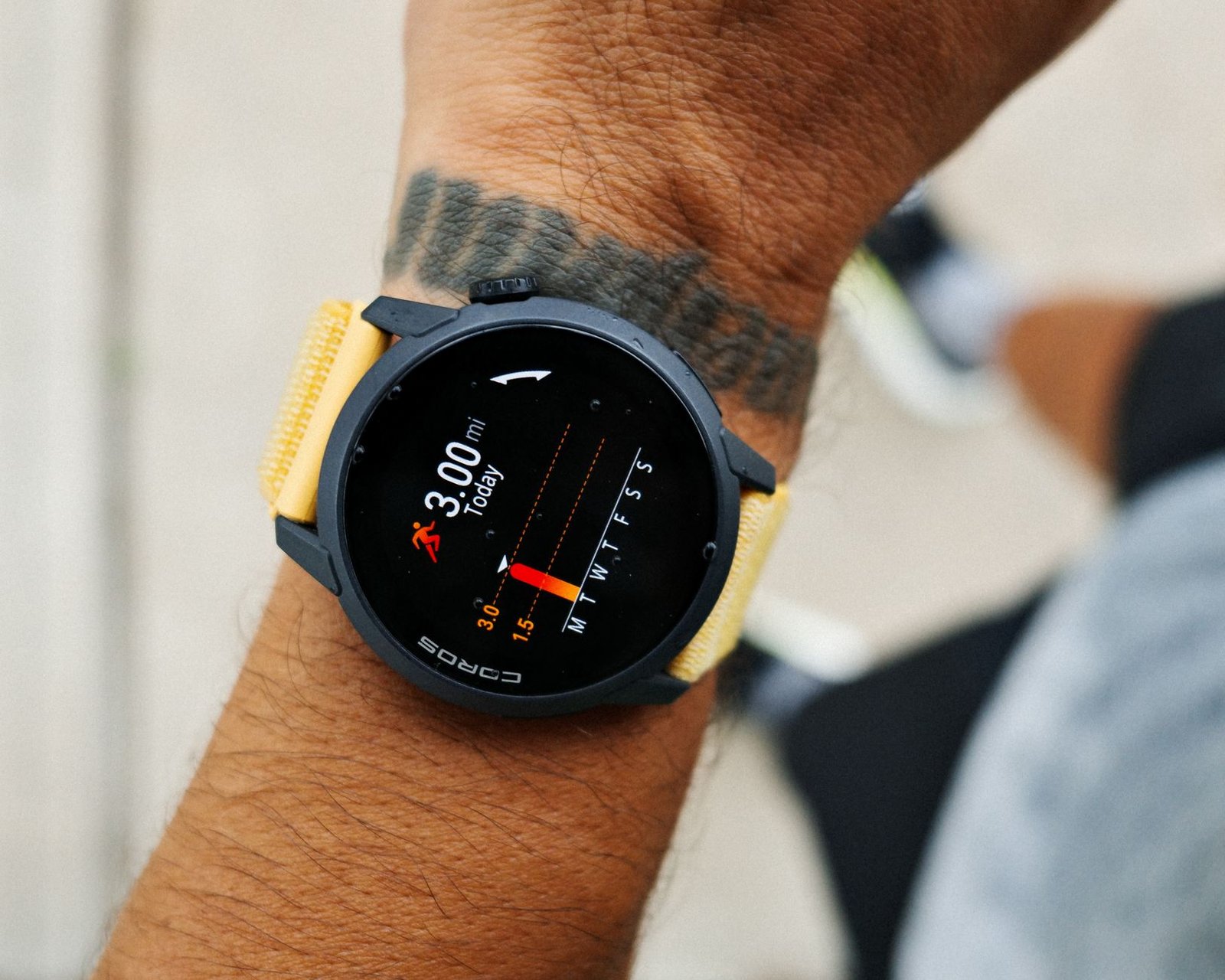 A sports smartwatch on a wrist displaying a three mile run in progress