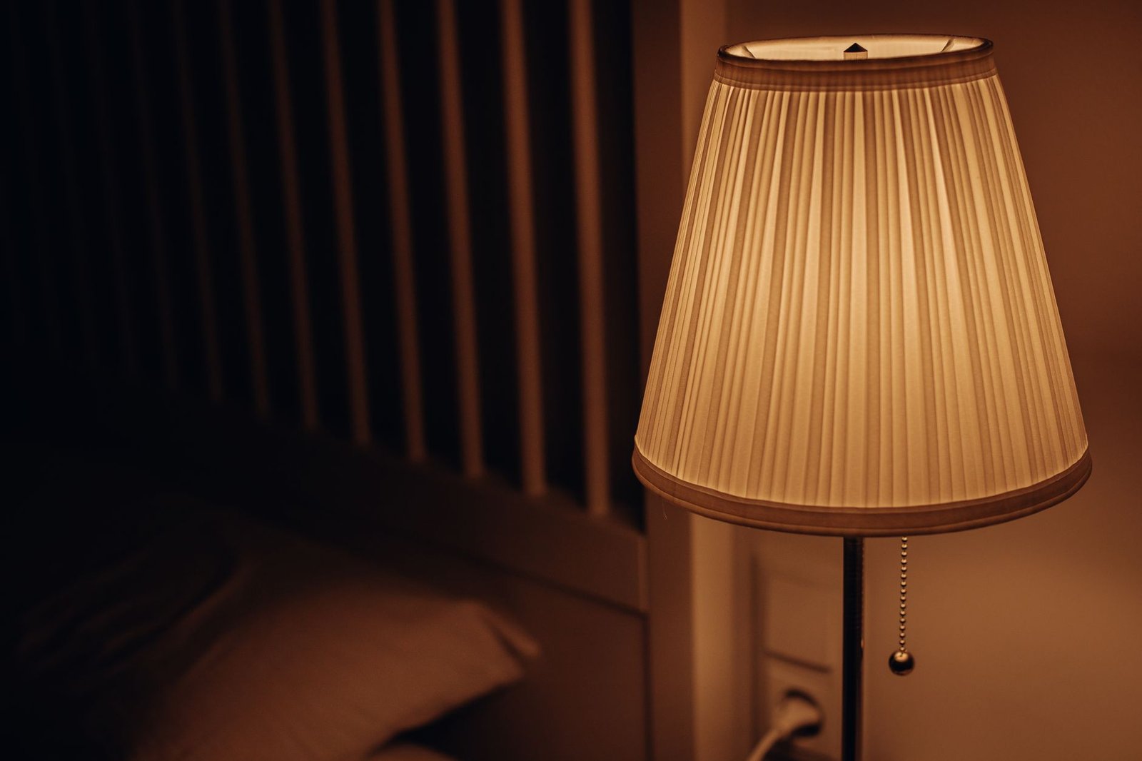 Warm bedside lamp glow like a sunrise alarm clock in a dorm room