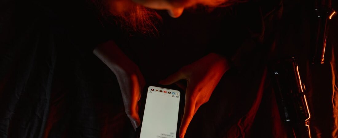 Person watching a video clip on a phone in dim light, wondering if it is real