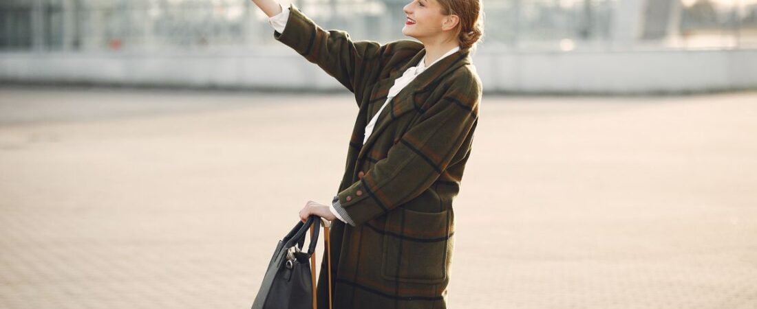 Cheerful traveler using her phone with a suitcase, connected abroad after landing