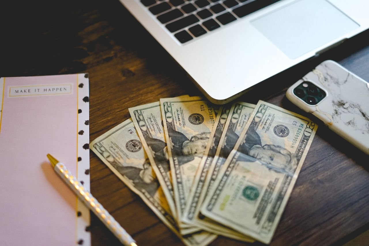 Cash beside a laptop showing the savings from waiting for Black Friday