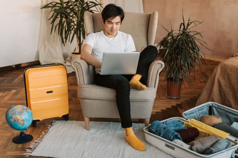 Setting up a travel eSIM on a phone at home before a trip with a suitcase and globe