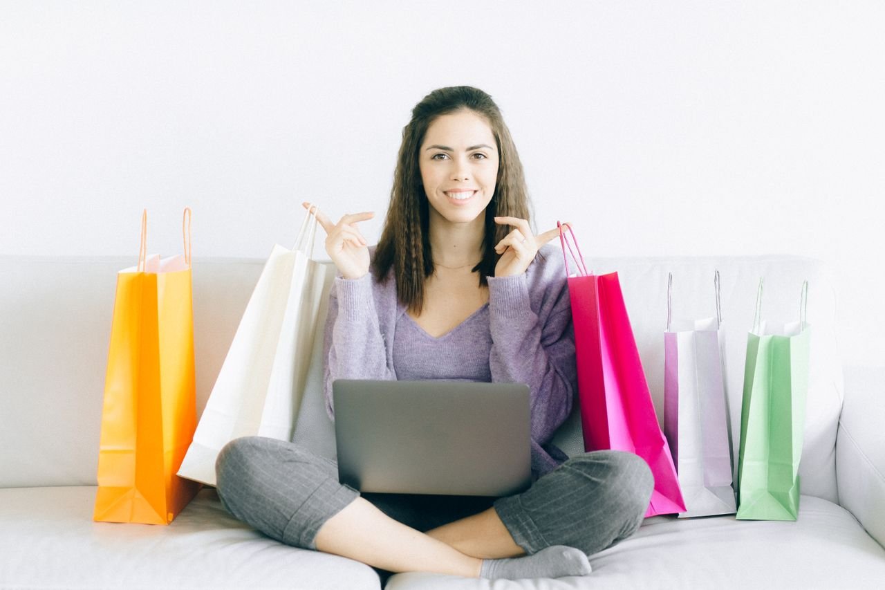 Shopper comparing a laptop on Labor Day weekend with colorful shopping bags