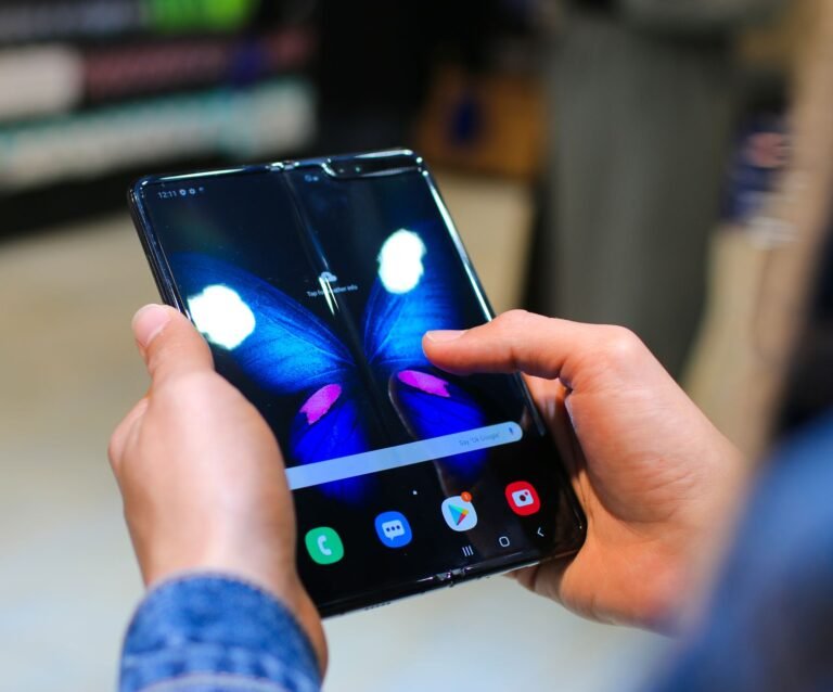 Someone holding an open book-style foldable phone with a vivid display