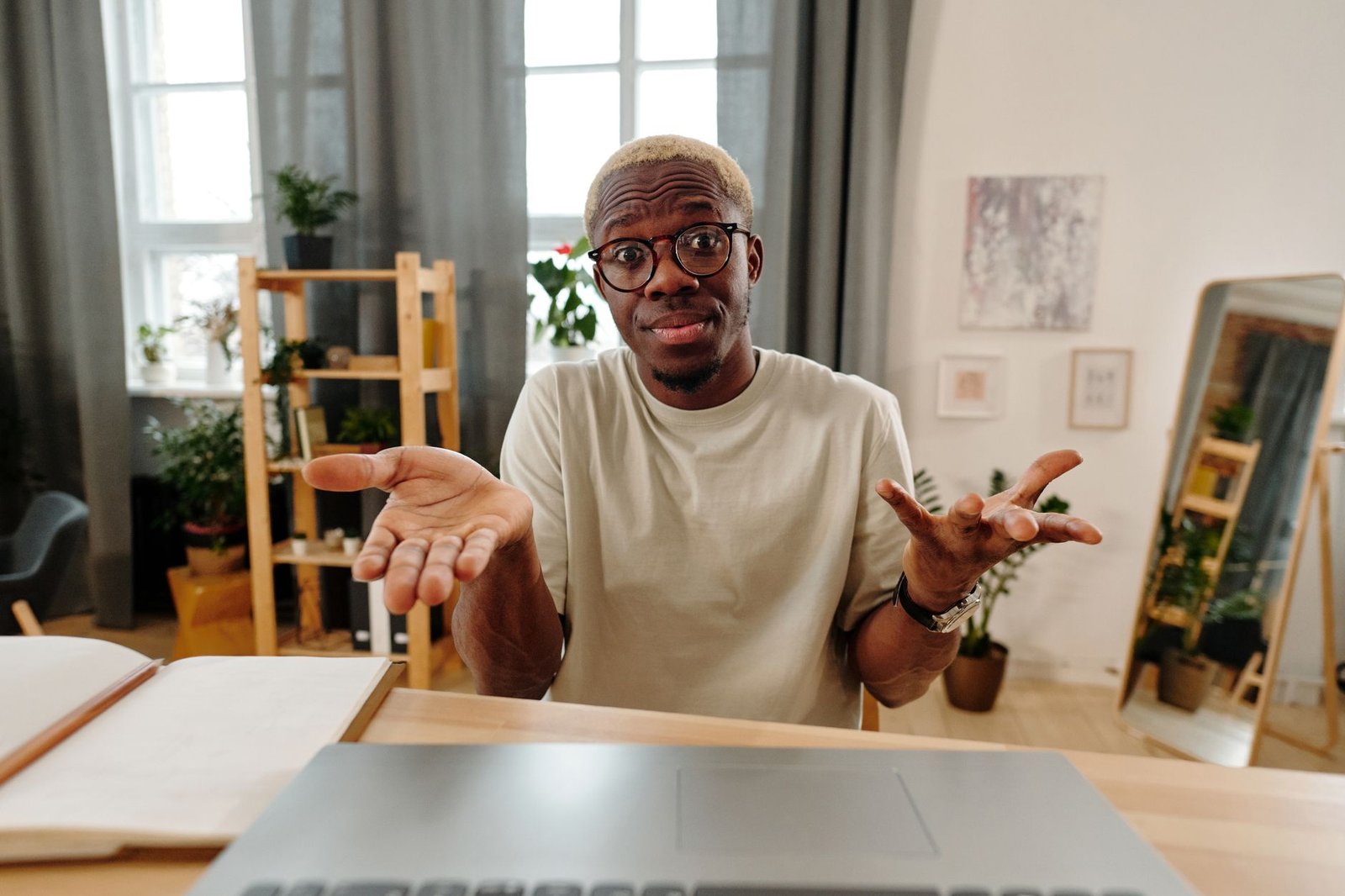 A puzzled man shrugging at his desk, reflecting Alexa+ early quirks.