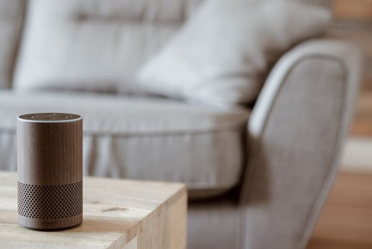An Amazon Echo smart speaker on a side table in a bright living room.