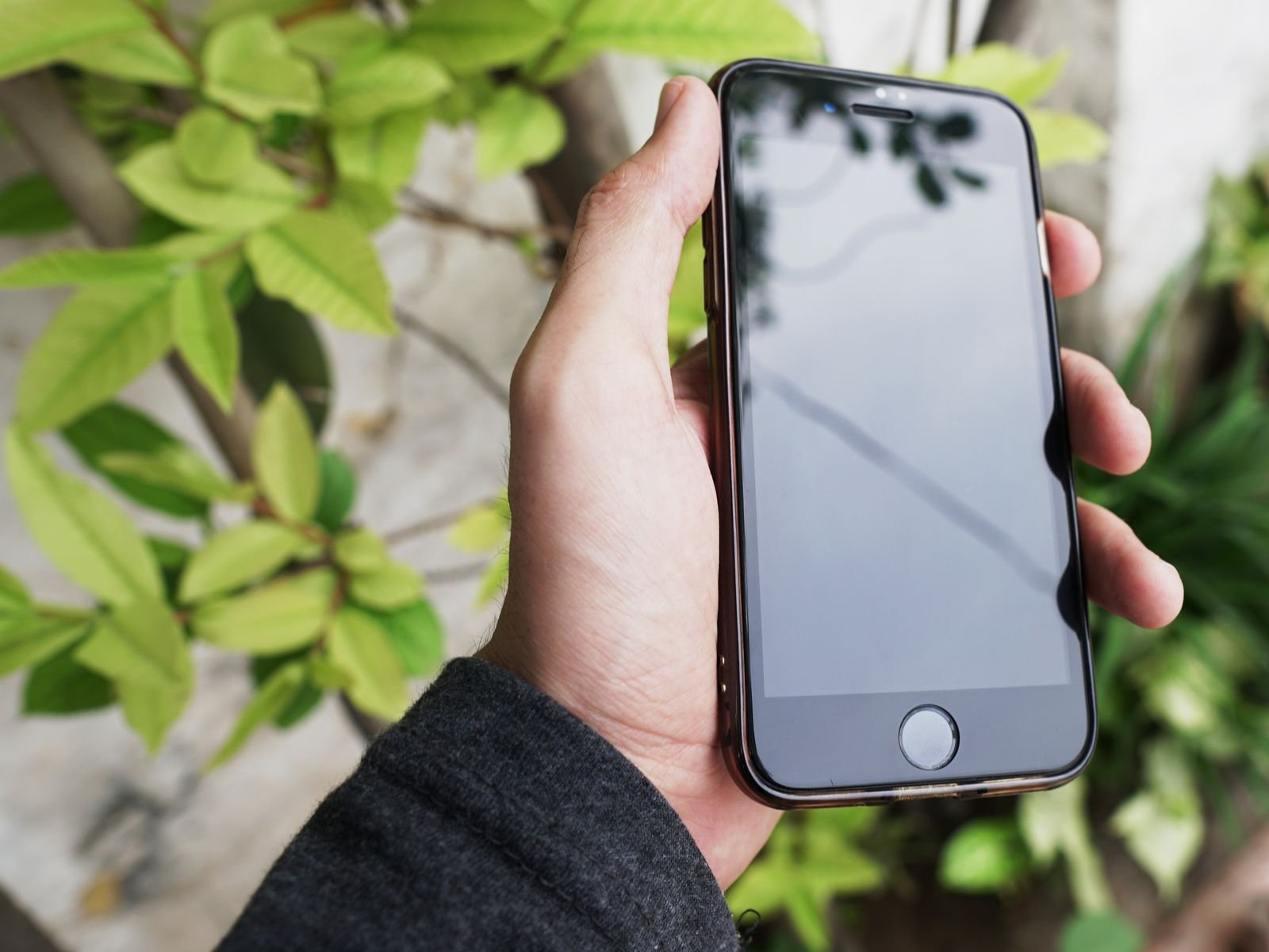 Hand holding an iPhone to check iCloud storage before making a backup