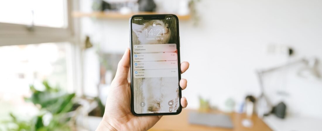 Hand holding a phone showing a backup notification, the kind of alert you get when Google Photos storage full stops your photos from saving