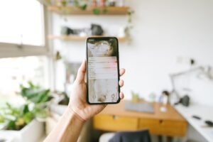 Hand holding a phone showing a backup notification, the kind of alert you get when Google Photos storage full stops your photos from saving