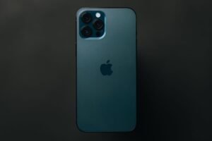 Pro-tier iPhone shown from the back in a dark studio, highlighting the rear triple camera