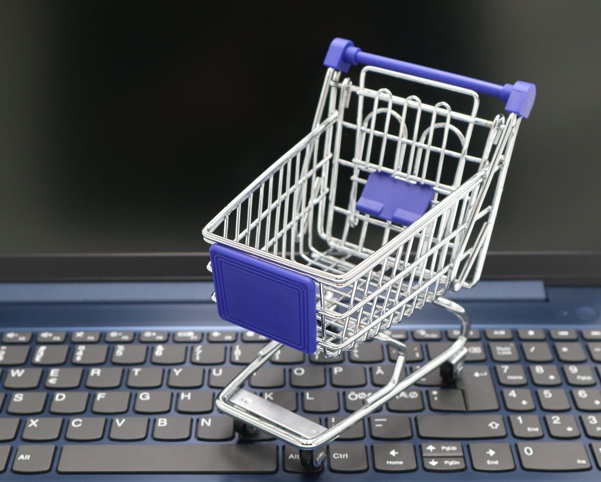 Mini shopping cart on a laptop keyboard representing online deal shopping