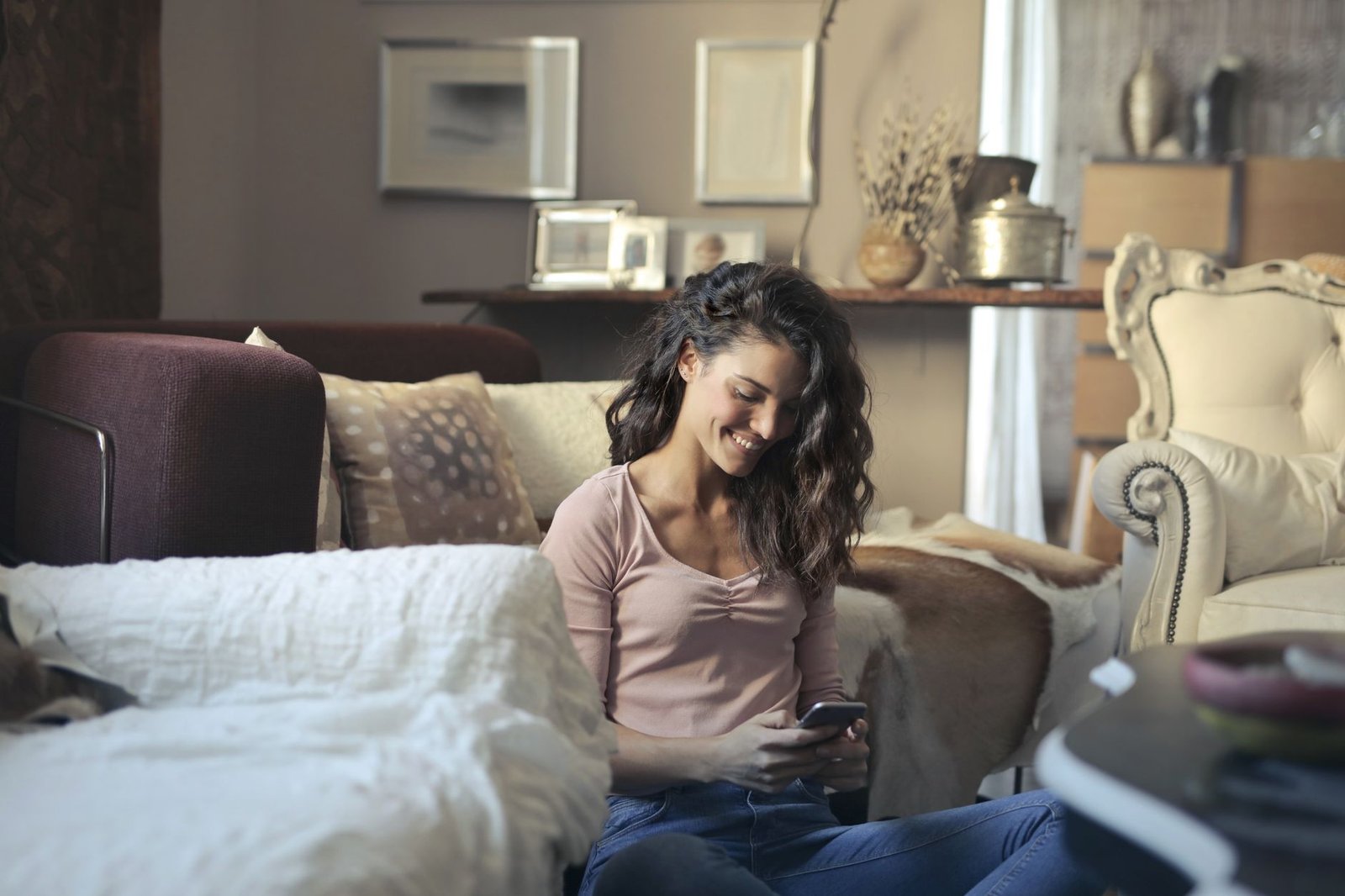 Person relaxing at home and smiling at their phone after reclaiming photo storage