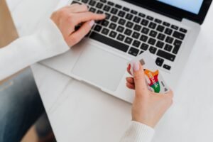 Shopper holding a credit card at a laptop checkout screen during a holiday sale