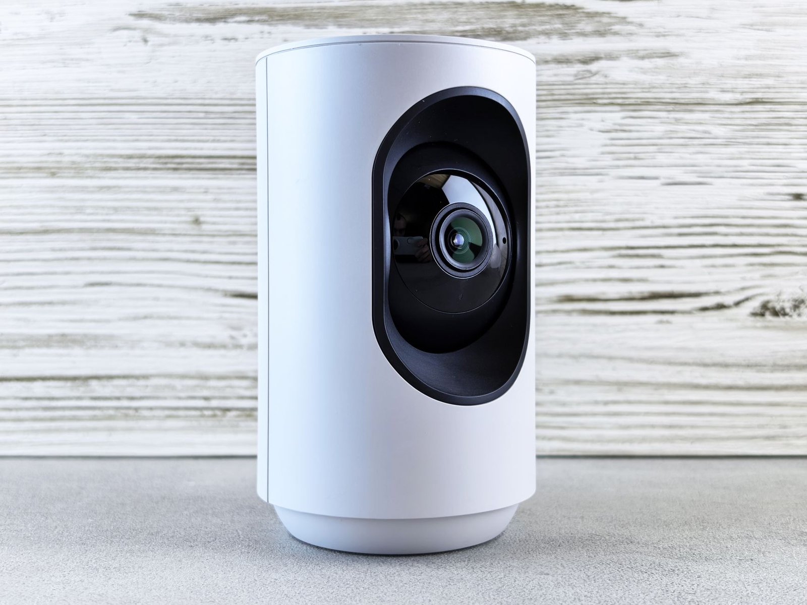 White indoor smart home security camera on a shelf