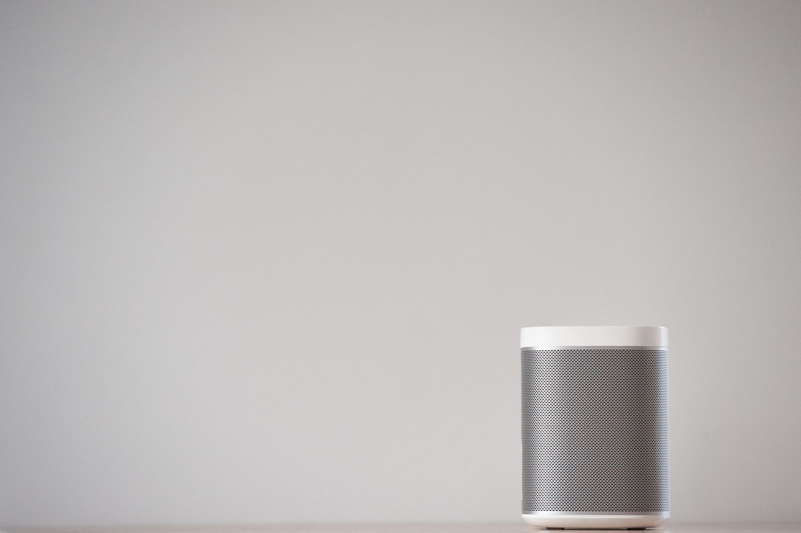 A smart speaker like the Echo Dot on a shelf